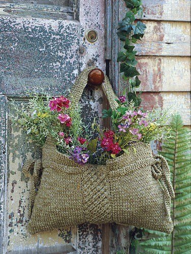 Use an old handbag or slingbag/basket, fill with container and flowers and hang on outside doors for welcome...: 