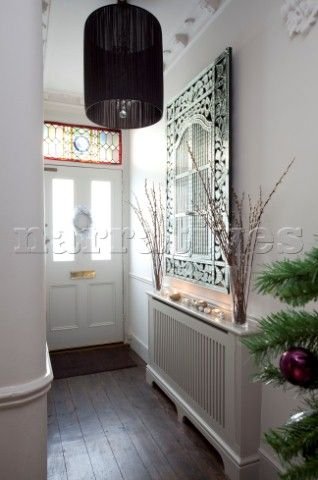 Bright and neat hallway with covered radiator: 
